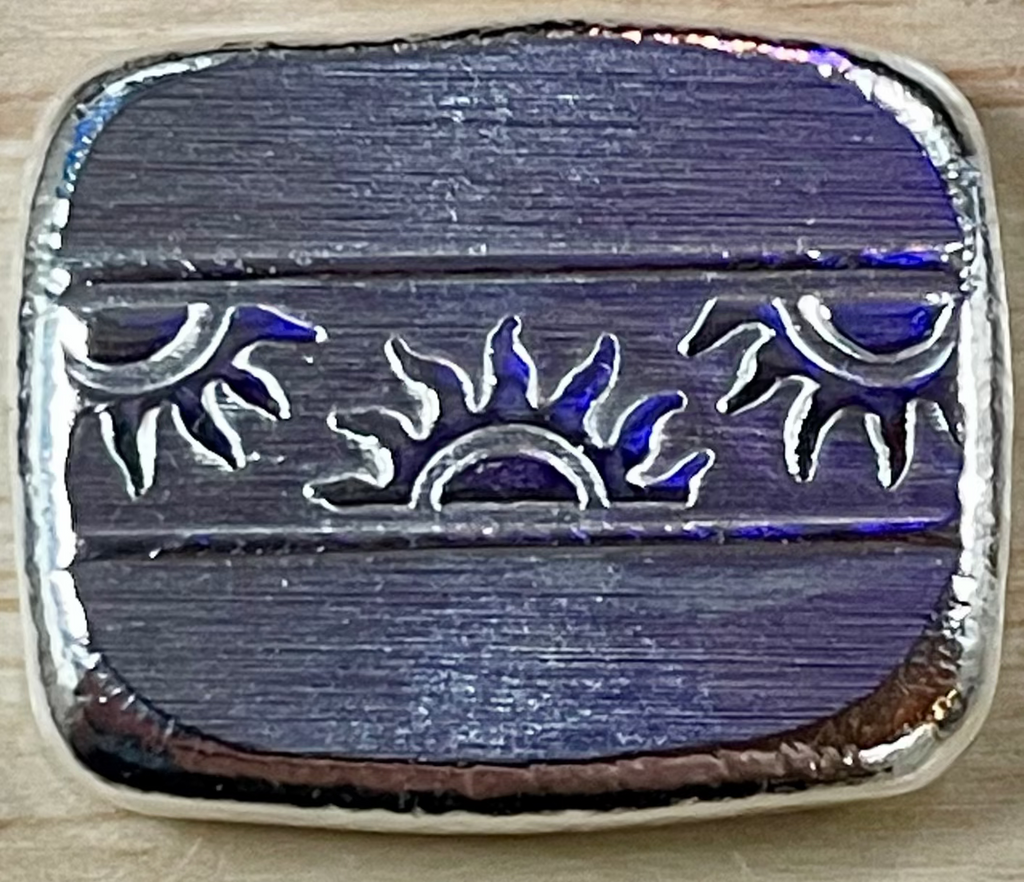 Metallic blue and silver decorative object on a wooden surface