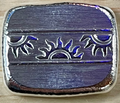 Metallic blue and silver decorative object on a wooden surface