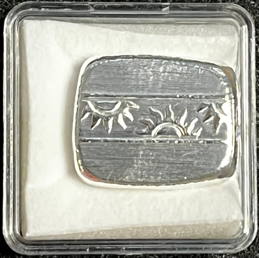 Silver bar with engraved design in a protective case on a dark textured background